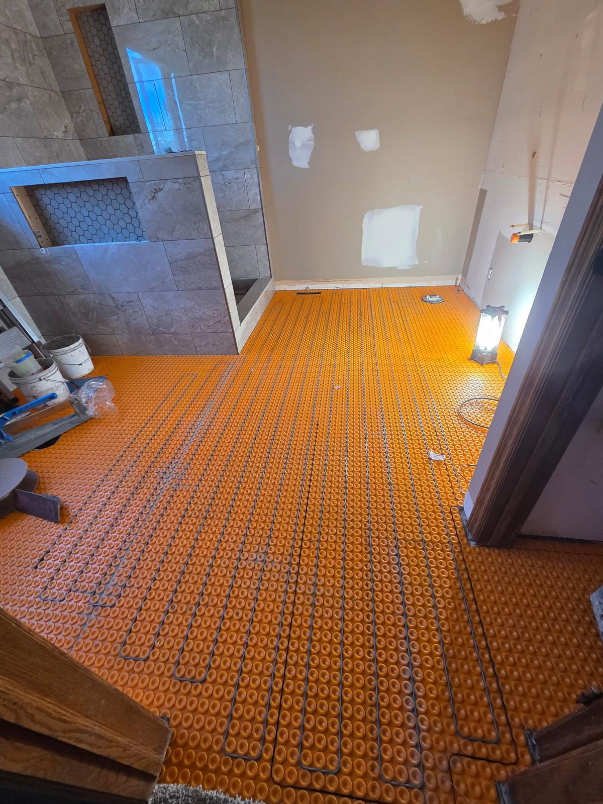 Heated floor cable laid into an uncoupling membrane before tile installation